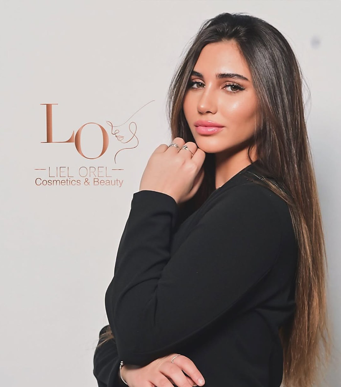 ליאל אוראל, בעלת הקליניקה, לצד הלוגו LO – Liel Orel Cosmetics & Beauty